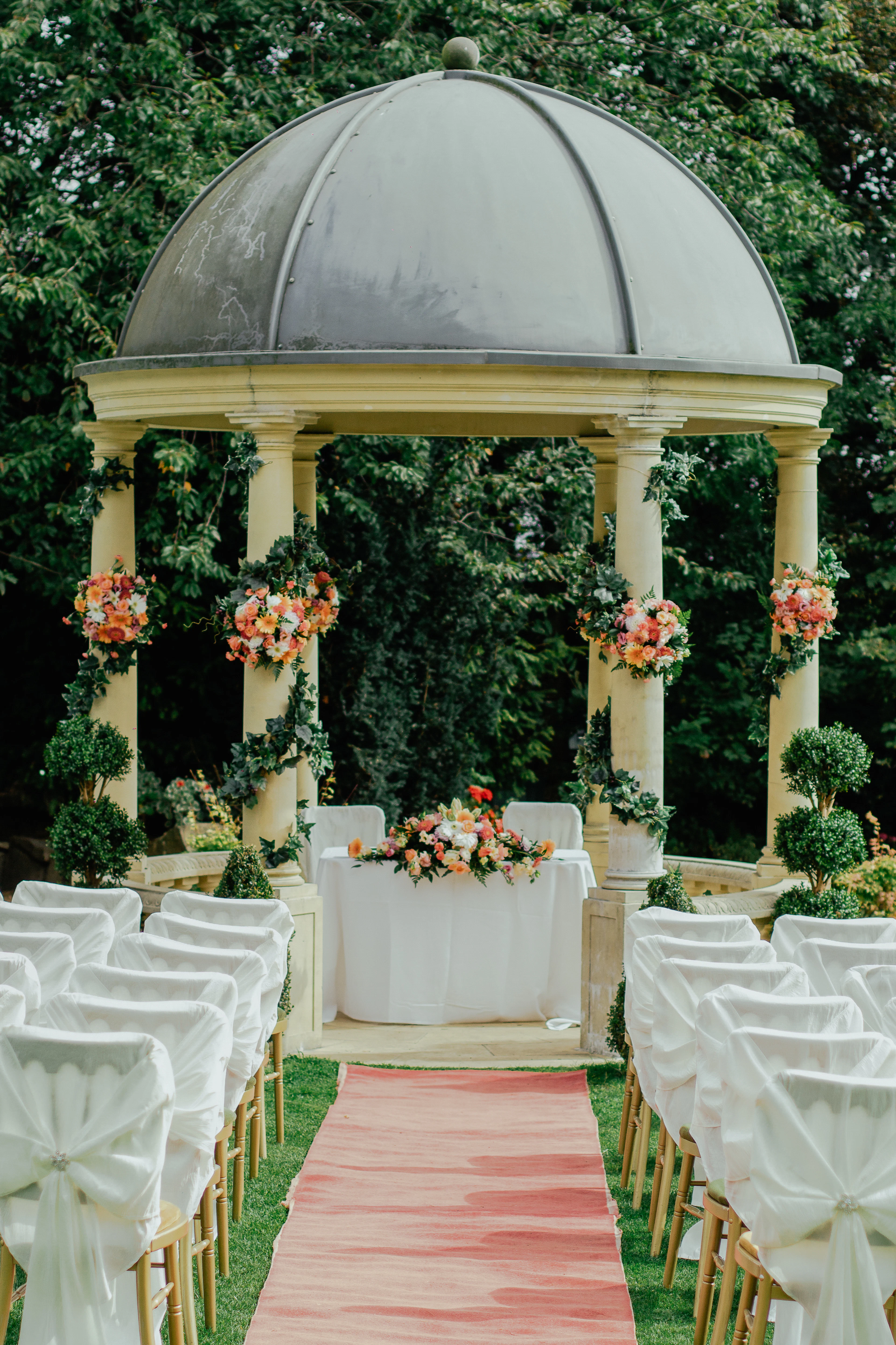 The ceremony arch framed by columns and cascading blooms