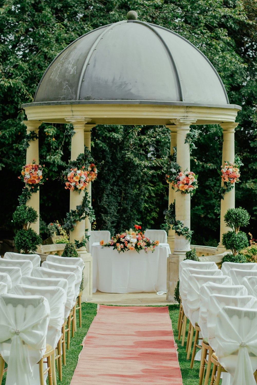 gazebo gris et beige près de l’arbre à feuilles vertes