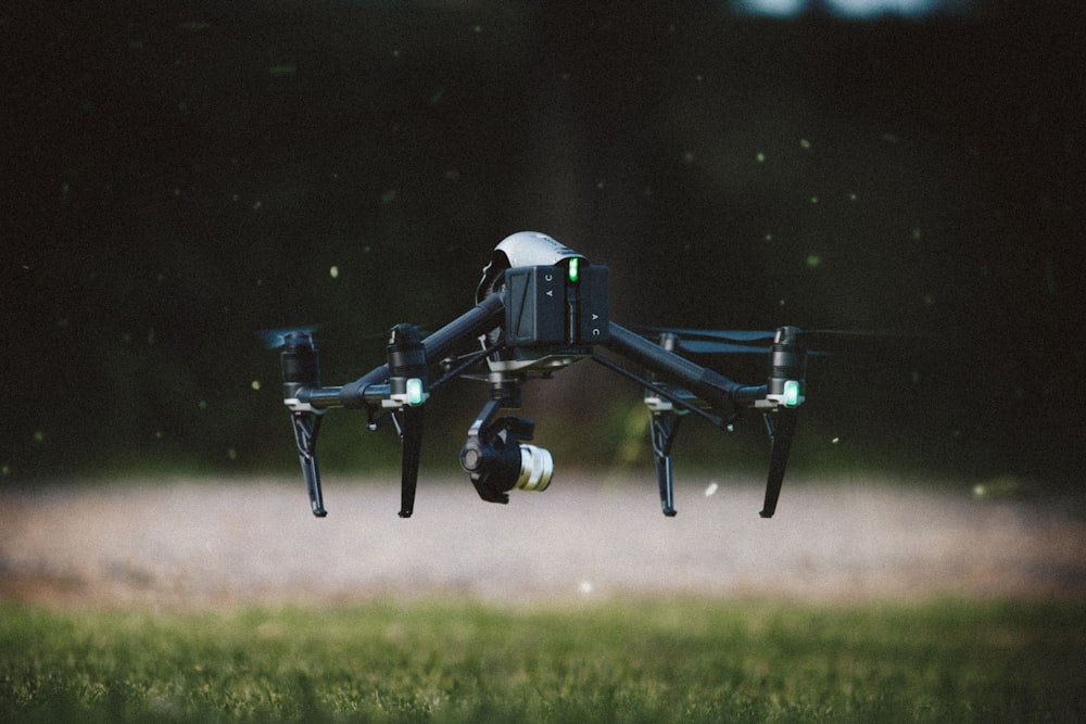 Photographie sélective de mise au point d’un drone quadricoptère noir et gris prenant son envol