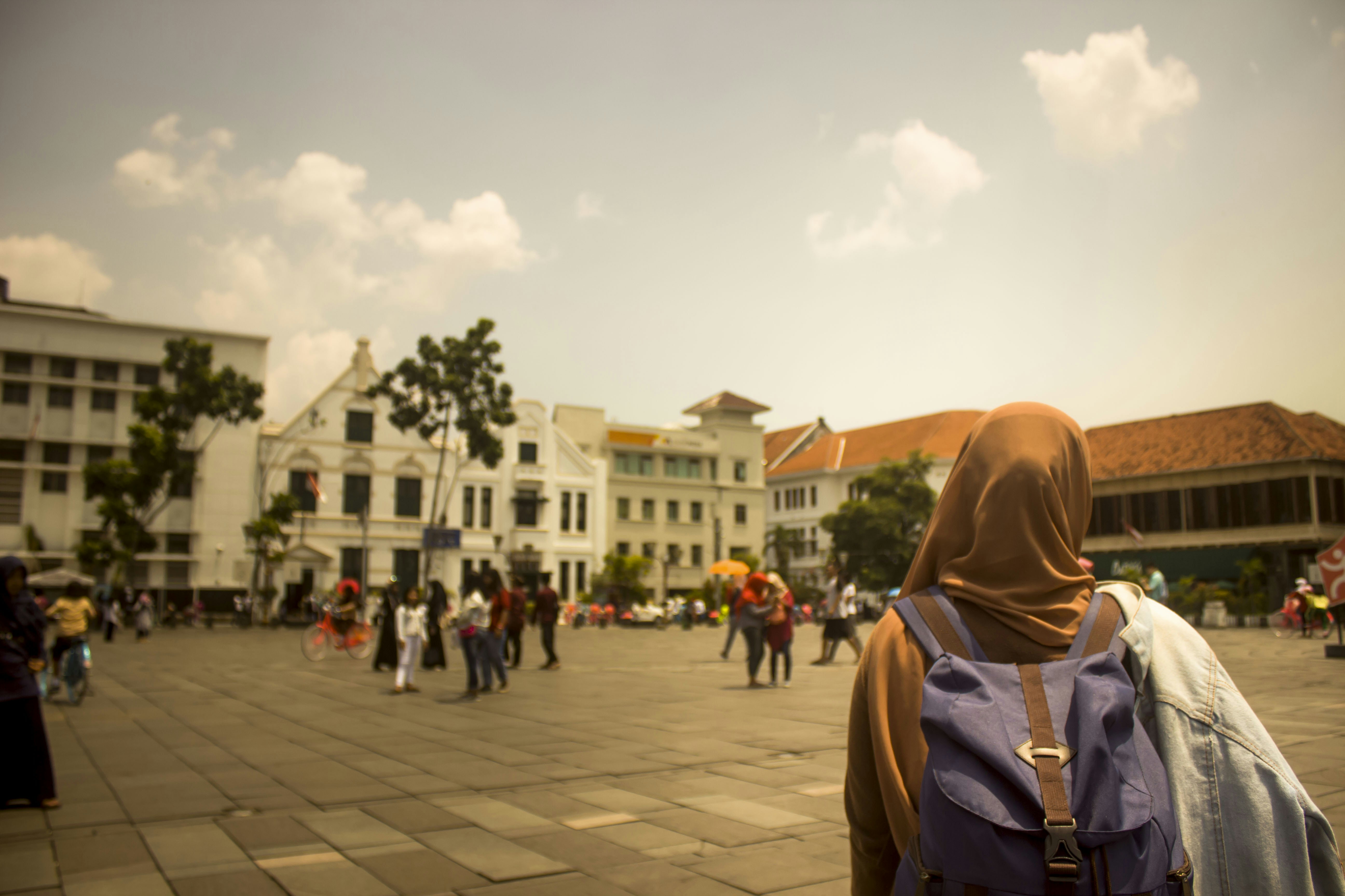 selective focus photograph of woman wearing hijab and purple backpack