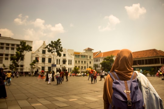 selective focus photograph of woman wearing hijab and purple backpack in Jakarta History Museum Indonesia