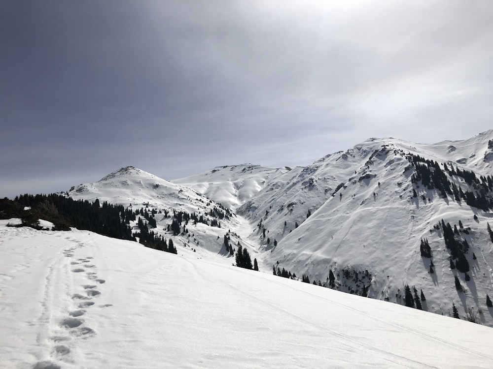 snow covered mountain under cloudy sky