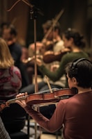 A group of students tuning their violins together before a workshop session.