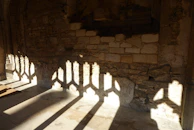 Delicate shadows cast by a lattice window onto a smooth stone floor, evoking quiet contemplation.
