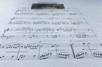 Close-up of traditional musical notes and religious symbols blending into a decorative background.