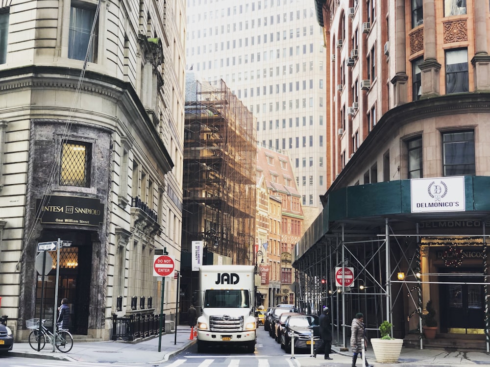 white vehicle between concrete building