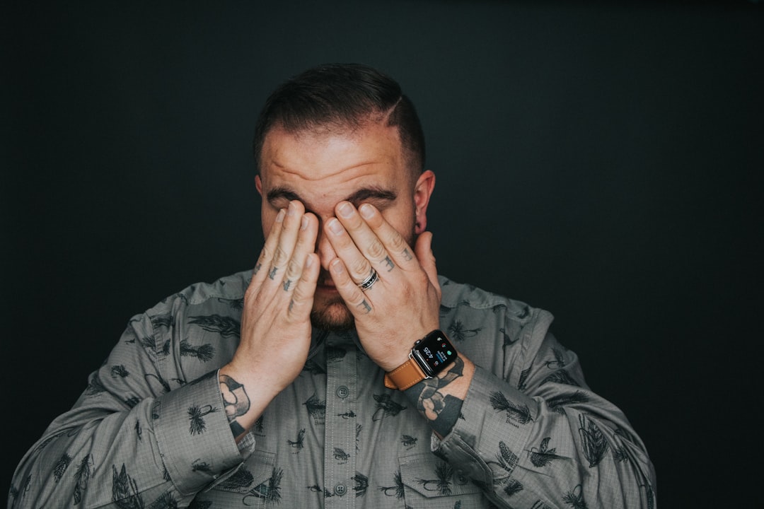 man covering his eye,