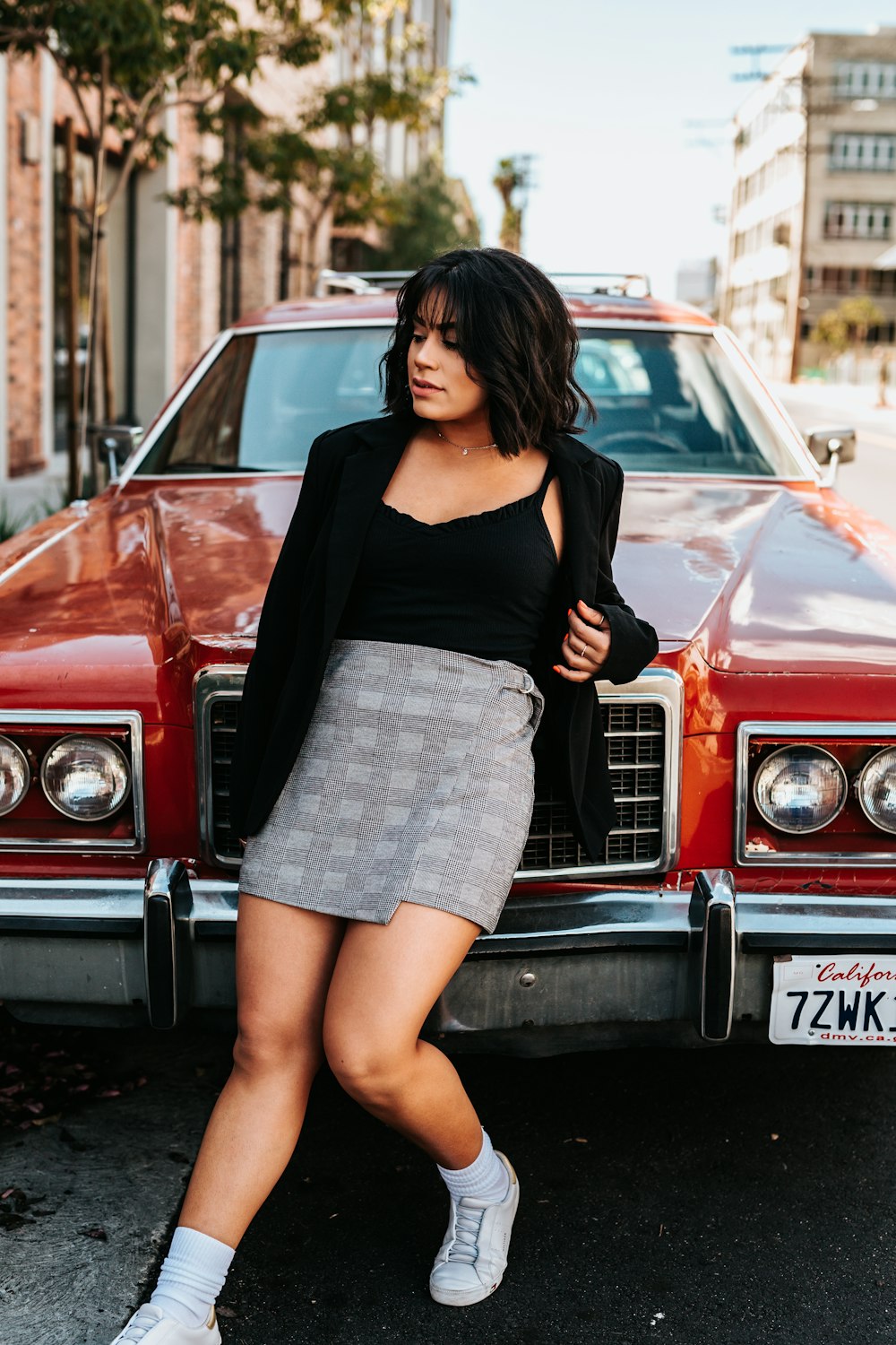 woman leaning on red car