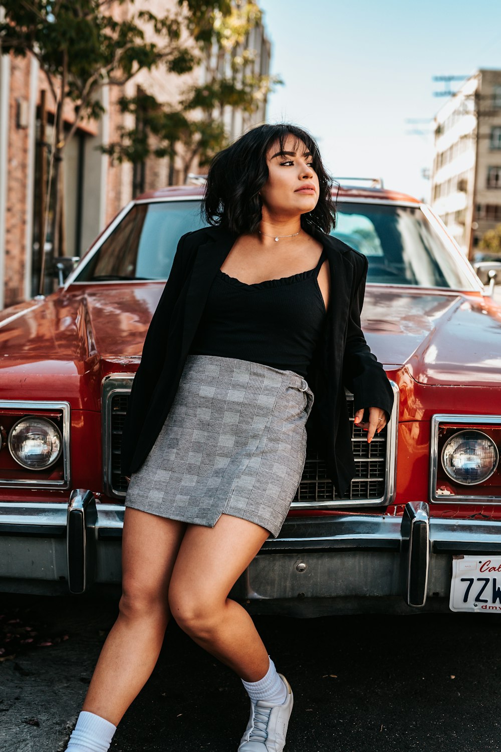 woman leaning on red classic car