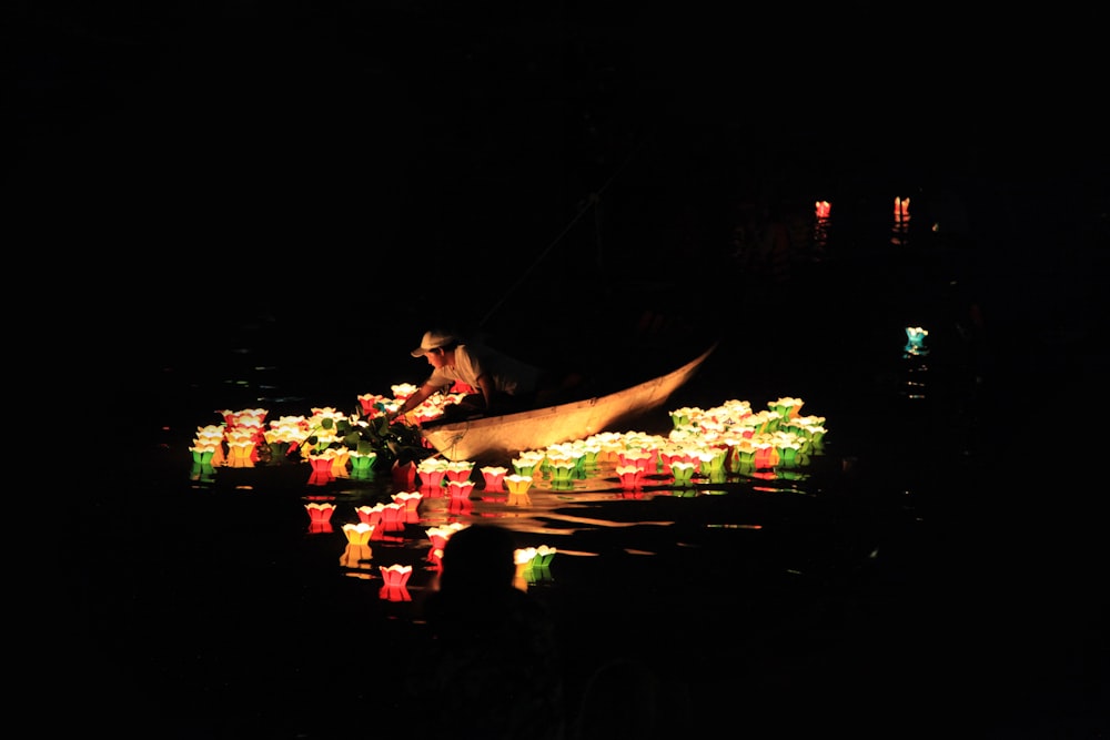 Mann reitet auf Boot mit Lichtern