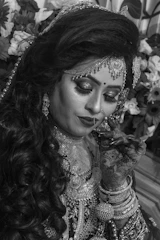 Bride with bold eye makeup and intricate henna designs on hands.