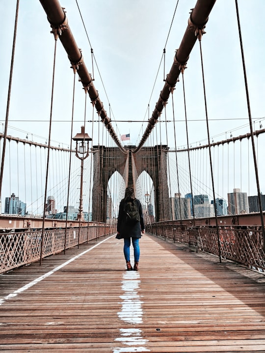 woman standing in bridge in Brooklyn Bridge United States