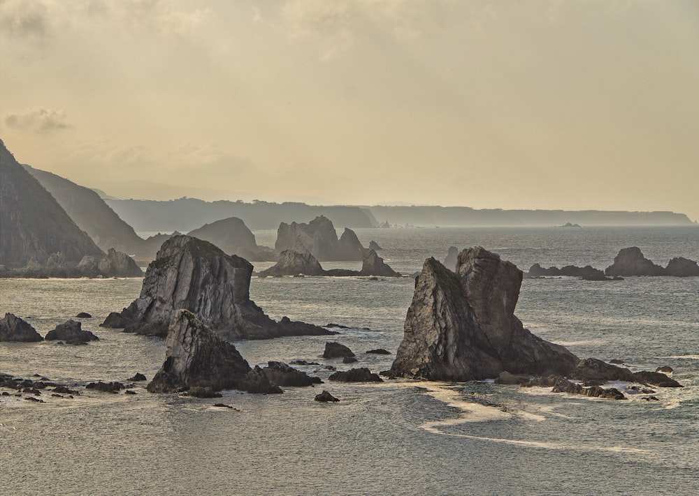 body of water near islands under white clouds