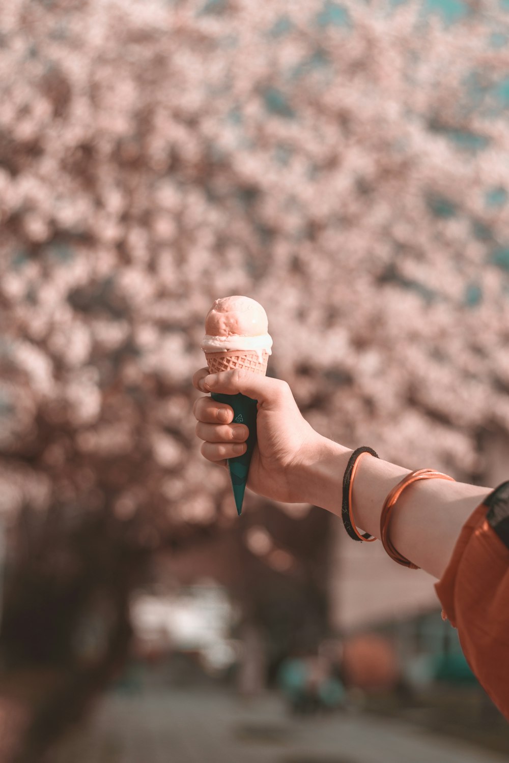 shallow focus photography of person holding ice cream