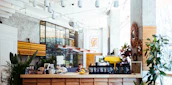 Warm interior with natural light highlighting artisanal coffee bags and local artwork.