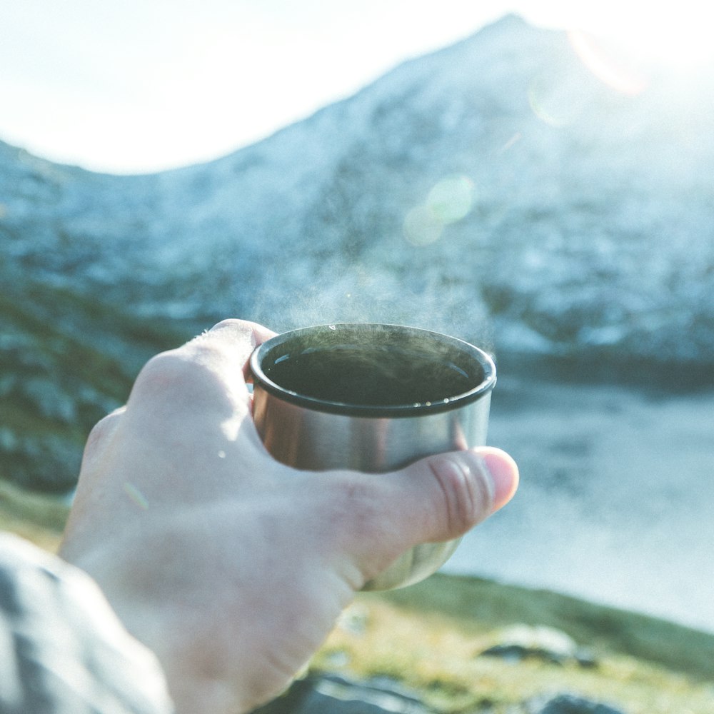 persona sostiene una taza