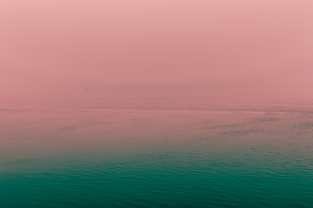 a large body of water with a boat in the distance