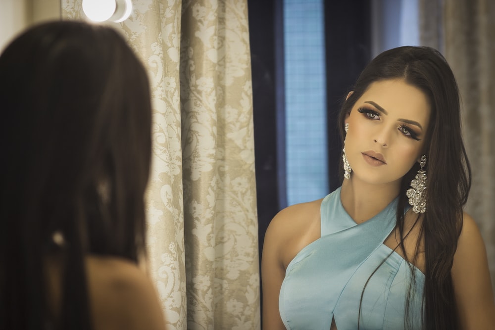 woman looking at her reflection in mirror