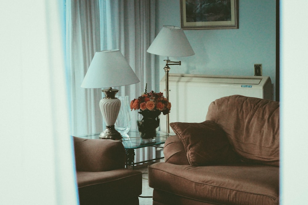 brown fabric sofa near two white table lamp and floor lamp turned off