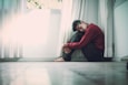 man beside white frame window