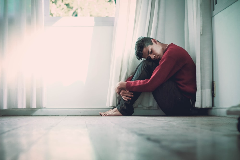 man beside white frame window