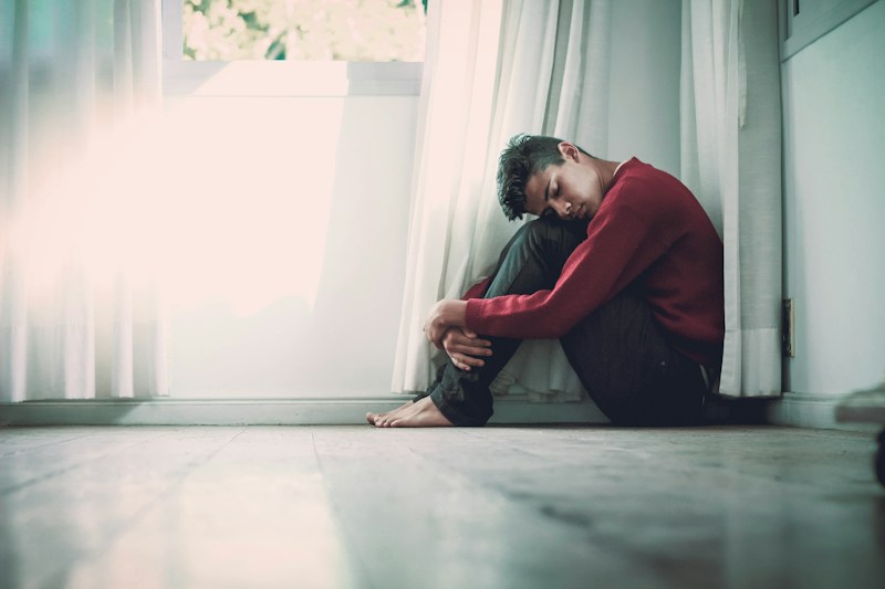 Person looking thoughtfully out window representing mental health reflection and treatment-resistant depression