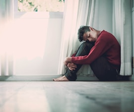 man beside white frame window