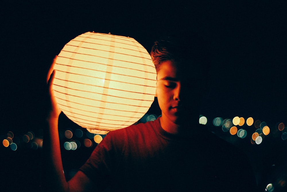man holding lantern during nighttime