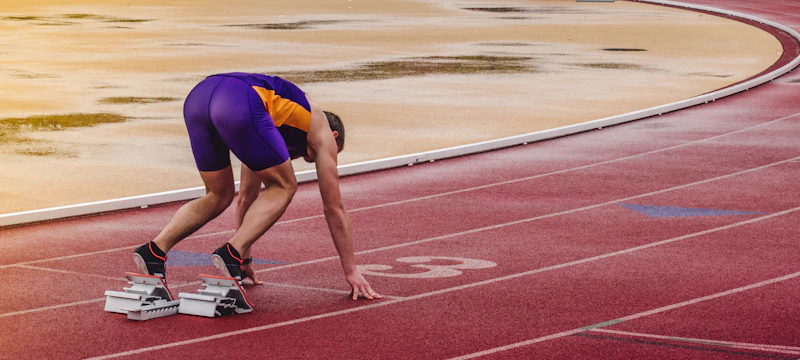 Runner set in the blocks on a track after completing a return-to-sport program
