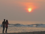 A couple enjoying a sunset on the beach.