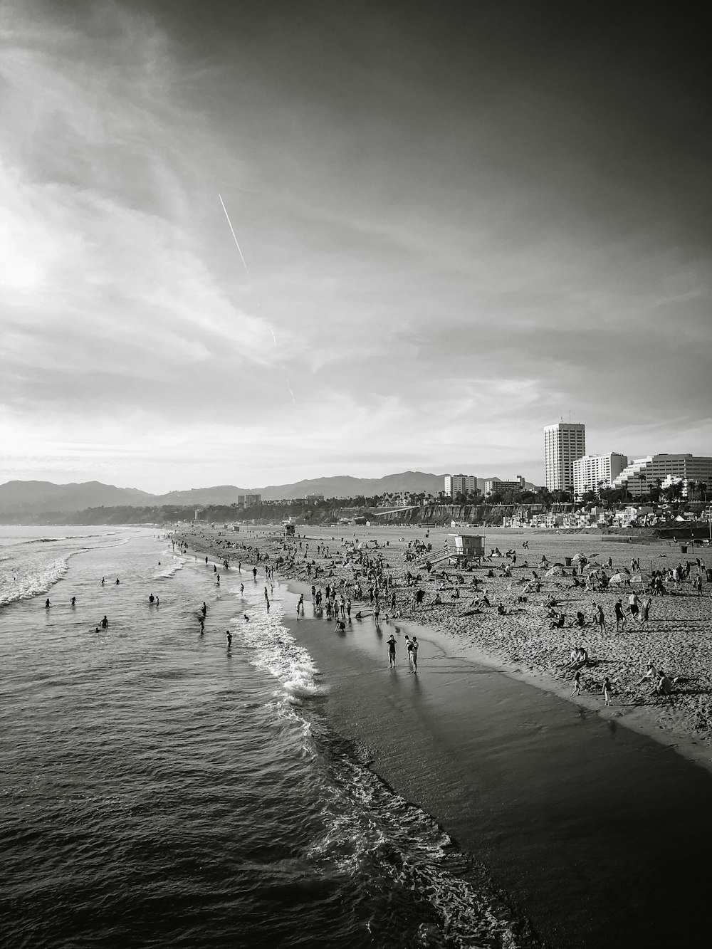 grayscale photography of people gathered near shore