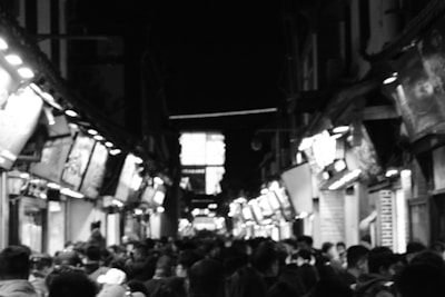 A vibrant city street scene with people walking and bright storefronts.