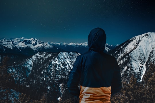 person wearing jacket facing mountains in Herzogstand Germany