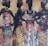Four silhouetted women are adorned in vibrant, patterned dresses with matching head wraps, set against a textured background of warm tones and abstract designs. They stand in confident poses, highlighting their elegant attire and jewelry.