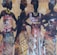 Four silhouetted women are adorned in vibrant, patterned dresses with matching head wraps, set against a textured background of warm tones and abstract designs. They stand in confident poses, highlighting their elegant attire and jewelry.