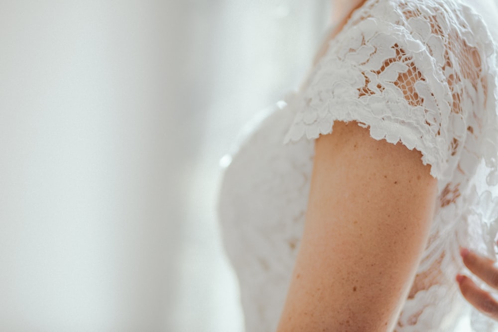 selective focus photo of woman wearing white lace top