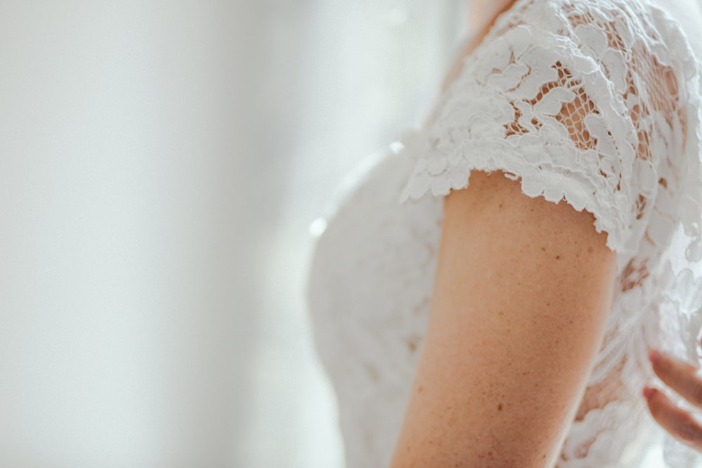 Foto di messa a fuoco selettiva di donna che indossa un top in pizzo bianco