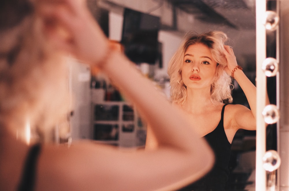 woman standing in front of vanity mirror