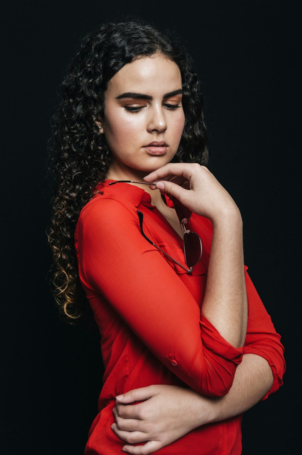 woman wearing red top against black background