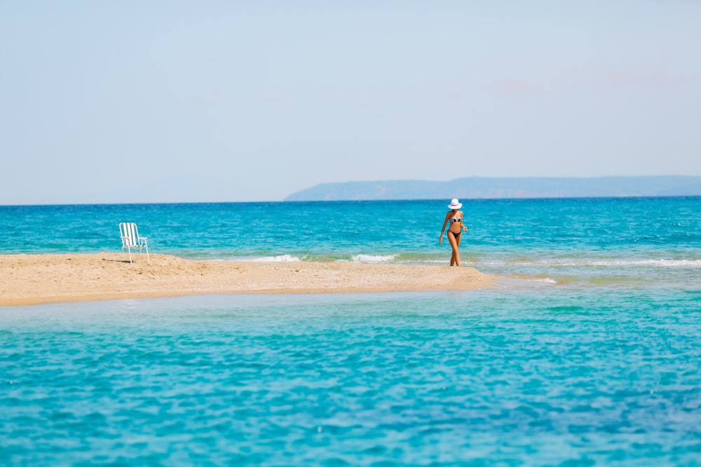 woman standing on sand bar during daytime