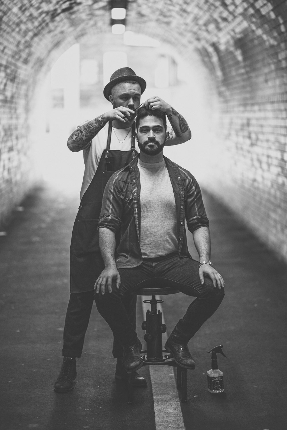 barber cutting mans hair inside tunnel