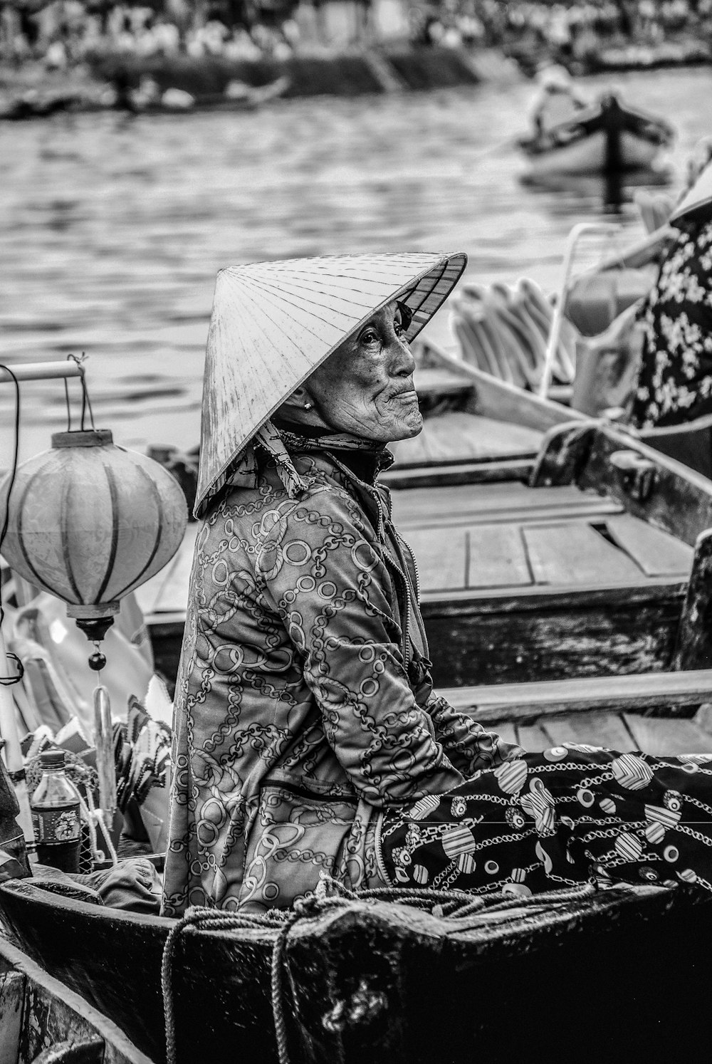 person in cone hat riding boat grayscale photography