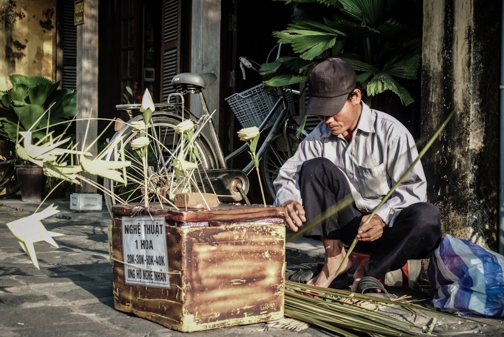 homme en chemise de robe grise faisant de l’artisanat de feuille