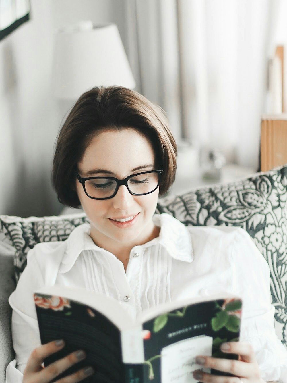 woman in black eyeglasses while reading book