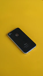 A sleek new iPhone displayed with bright orange accents on a black background.