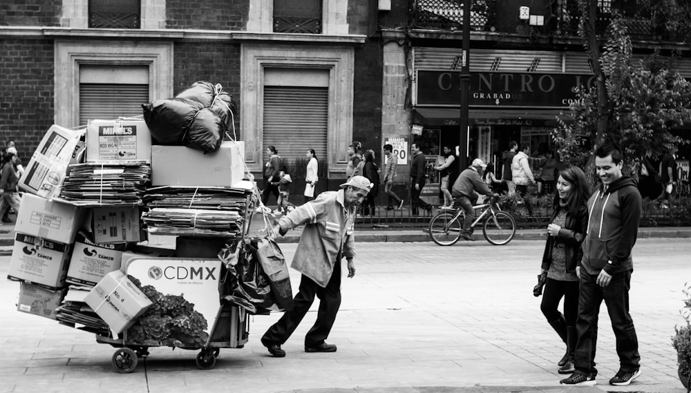 homme traînant un chariot avec des boîtes en carton
