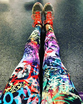 Close-up of sleek black and neon green gym leggings on a model mid-stretch