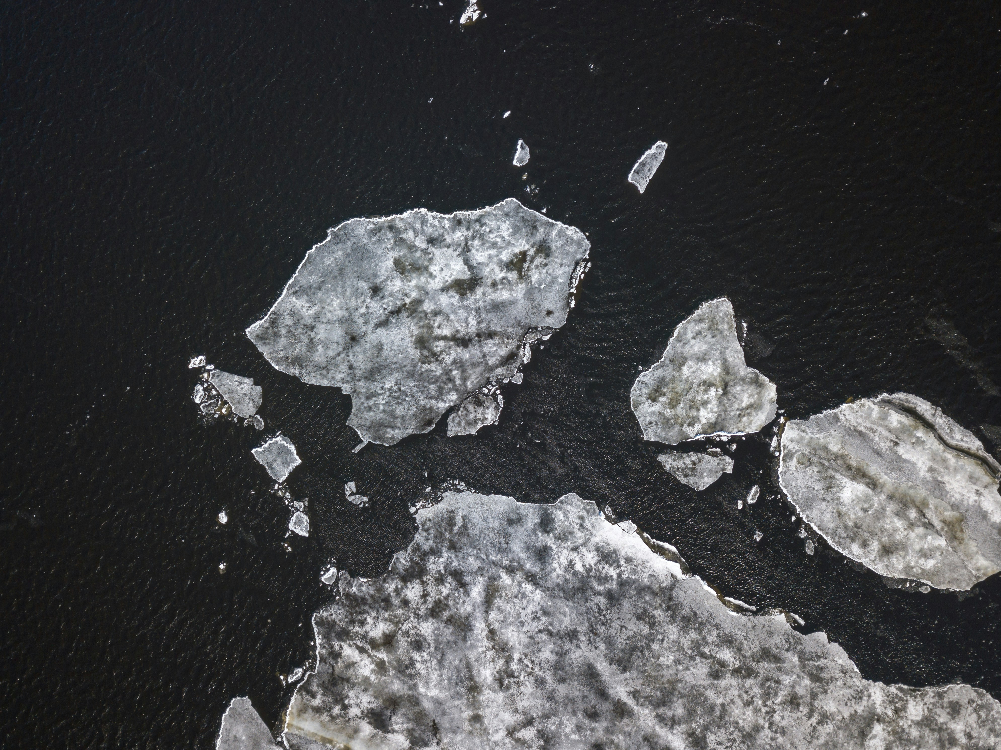 an image of a few chunks of melted ice floating into the black darkness of the sea
