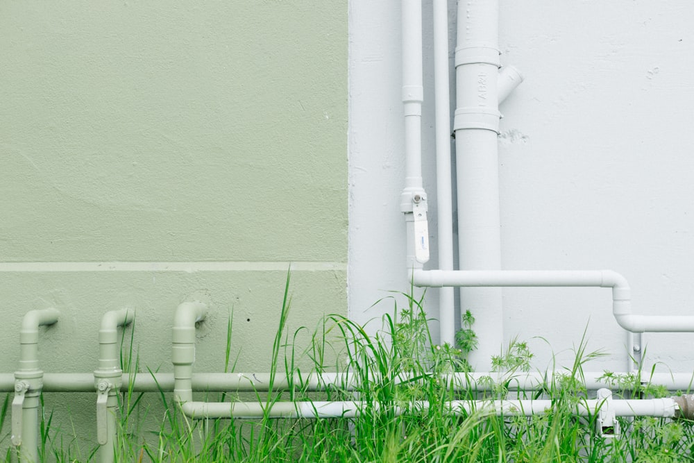 white metal water pipe near grass