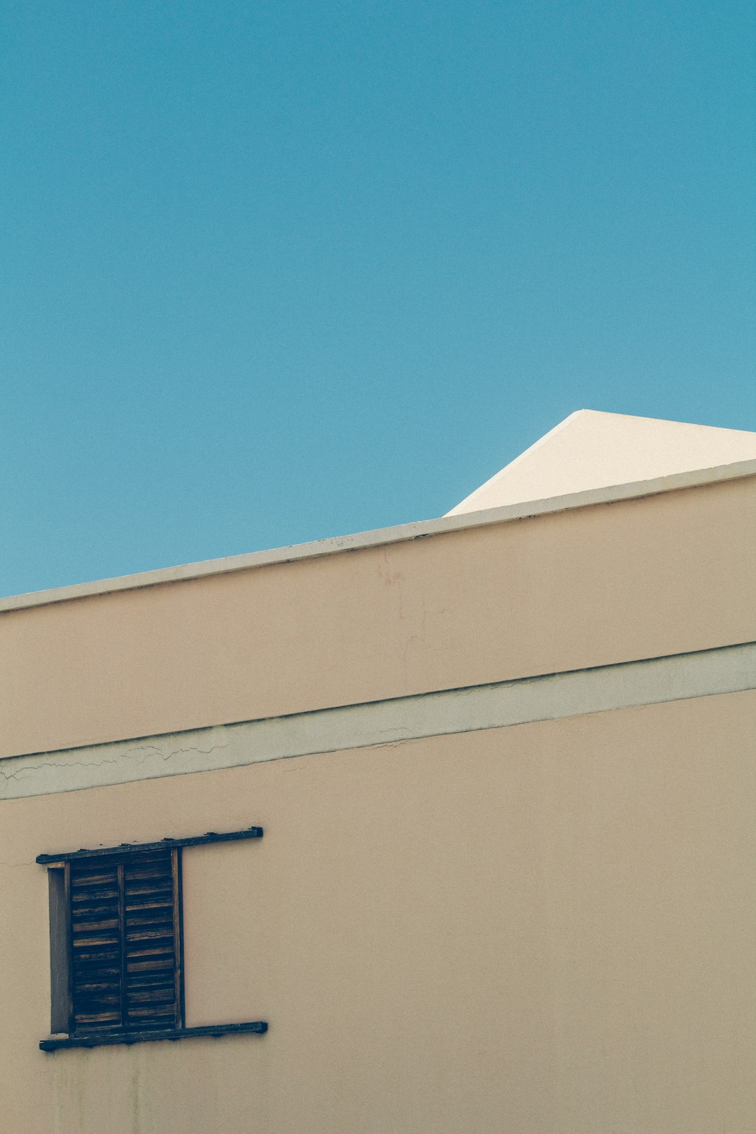 brown wooden louver window on concrete wall during daytime